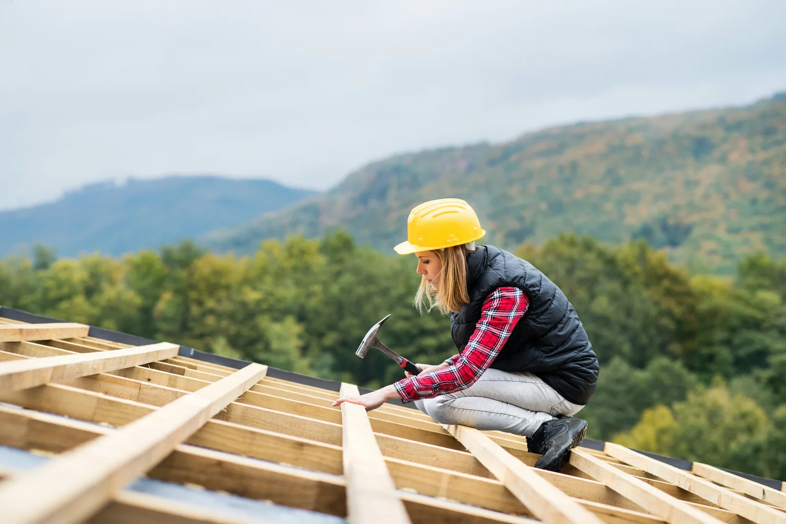 Roofer hammering roof framing